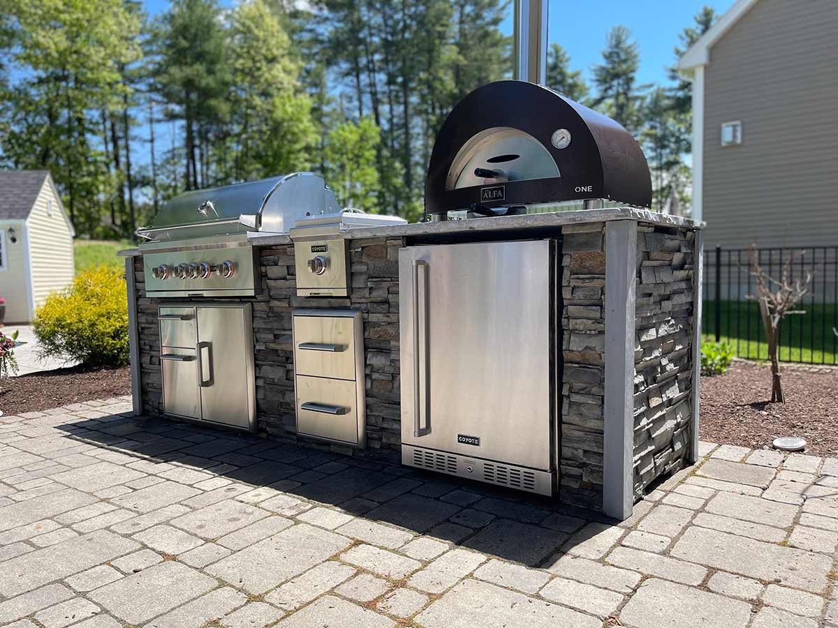 Outdoor kitchen grill station and pizza oven built in a Texas backyard by Postmasters Fencing