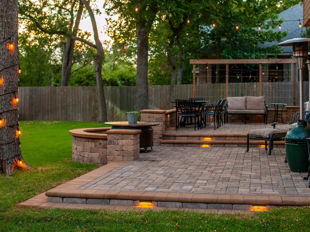 Custom stone paver patio installation in a Texas backyard by Postmasters Fencing